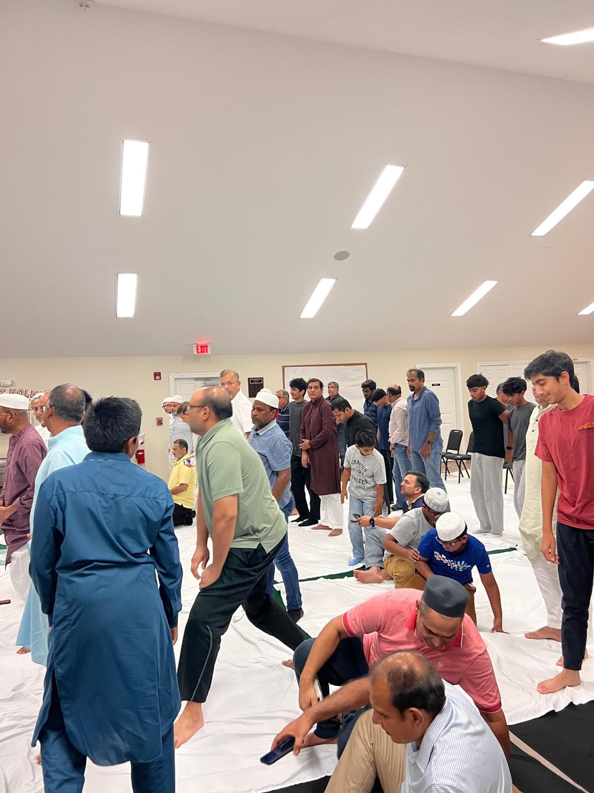 Community members gathering on prayer mats in the Jumu’ah hall